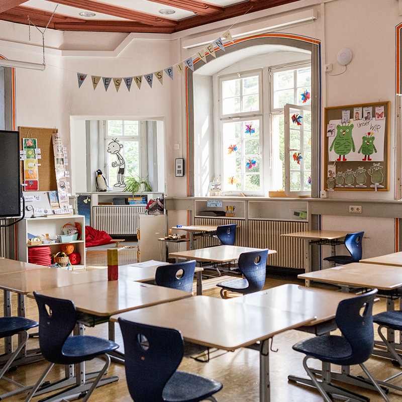 Schule im Schloss, Blick in ein Klassenzimmer mit Tischen, Stühlen uns Deko