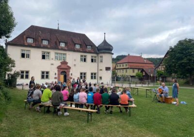 Abschluss des Schuljahres mit Eltern, Schülern und Lehrkräften auf der Wiese hinter dem Schulgebäude.
