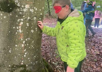 Schüler erkunden den Wald mit verbundenen Augen